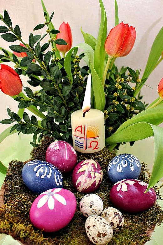 gefärbte Eier in einer Schale, brennende Osterkerze, rote Tulpen mit Buchs (c) k-h. gefärbte Eier in einer Schale, brennende Osterkerze, rote Tulpen mit Buchs